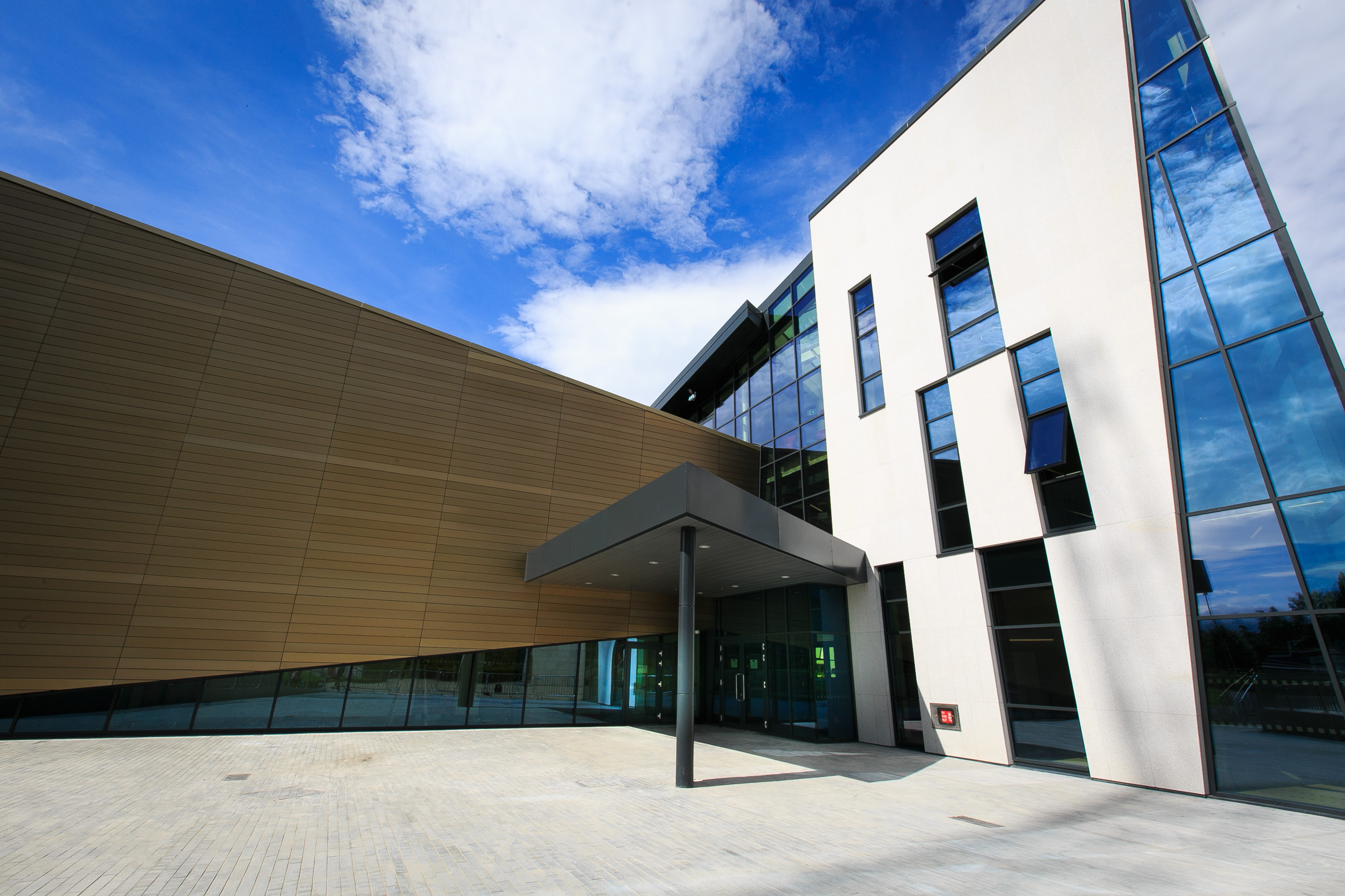 A white building with dark rectangular windows and a small porch